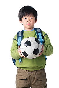 小学体育锻炼摄影照片_拿着足球的男孩