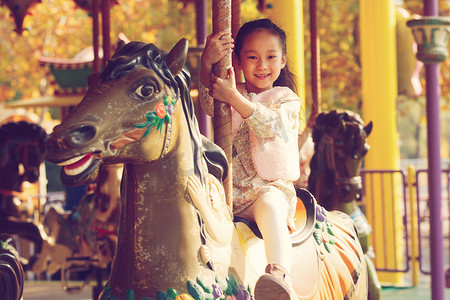 一个小女孩在玩旋转木马