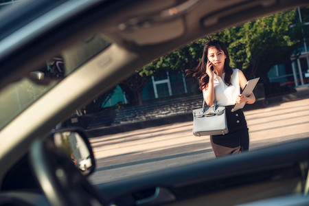 打电话的青年女人走向汽车