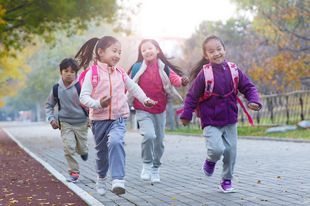 小学生自我介绍摄影照片_欢乐的小学生在户外奔跑