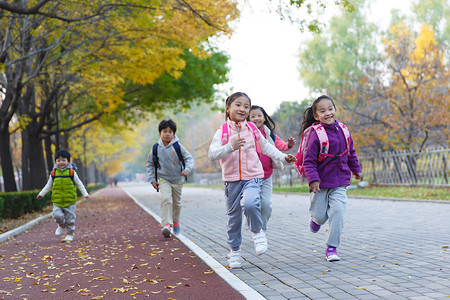 秋天摄影照片_欢乐的小学生在户外奔跑