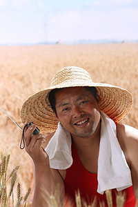 一个农民在麦田里听收音机