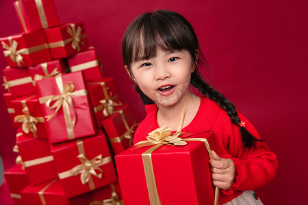 儿童节日礼物摄影照片_快乐的小女孩收到许多节日礼物