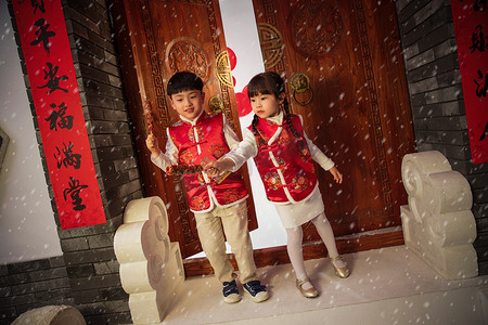 下雪玩耍摄影照片_欢乐的男孩女孩在门口玩耍