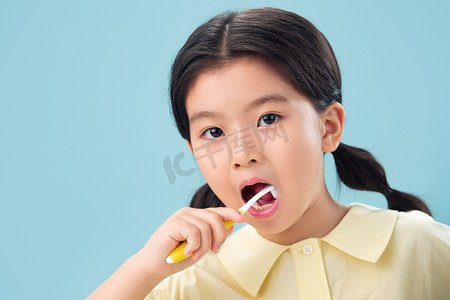 彩色牙刷摄影照片_拿着牙刷刷牙的小女孩