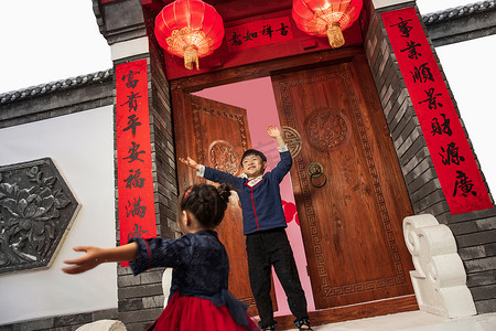 新年新中式元素摄影照片_新年在门口玩耍的快乐男孩女孩