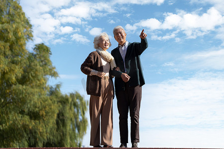 手指天空摄影照片_老年夫妇在户外散步