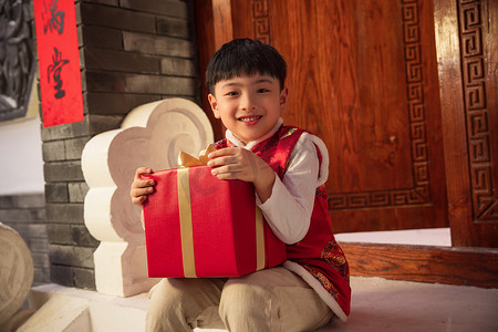 冬天小男孩摄影照片_可爱的小男孩抱着礼品盒