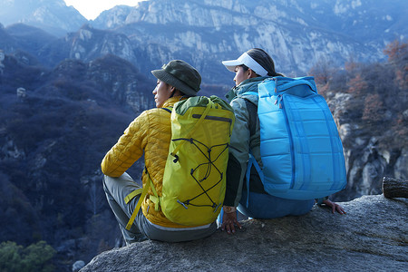 青年登山者伴侣坐在岩石上