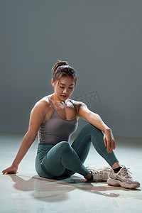 健身的青年女人坐在地上休息