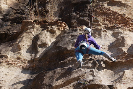 极限攀岩摄影照片_青年女人在悬崖峭壁上攀岩