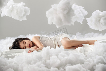 创意云朵装饰摄影照片_可爱的小女孩躺在云朵上
