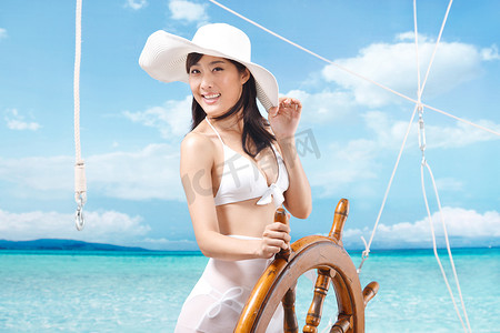 彩色船舵摄影照片_东方女人海滩休闲生活