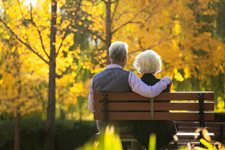 看黄色摄影照片_幸福的老年夫妇坐在长椅上看风景