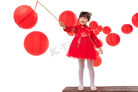 灯笼传统元素摄影照片_红灯笼旁提着灯笼玩耍的小女孩