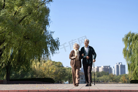 老年女人搀扶老伴在户外散步