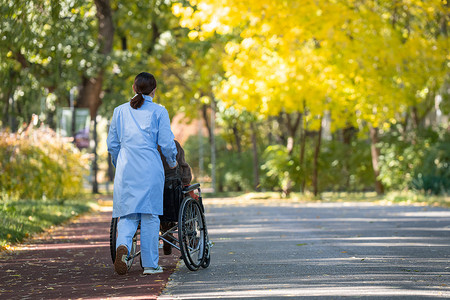 老人轮椅摄影照片_护士推着坐在轮椅上的老人散步