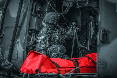 军事冲突摄影照片_直升机撤离一名受伤士兵。受害者躺在担架上。1.军事冲突的概念。高质量的