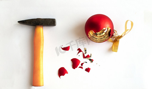 白色背景的铁锤碎了的圣诞球。脆弱的概念和假期的短暂