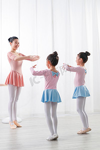 舞蹈女孩们摄影照片_年轻舞蹈老师教小女孩们跳芭蕾