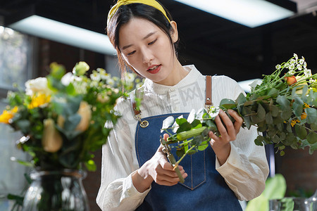 植物女人摄影照片_插花师在工作室插花