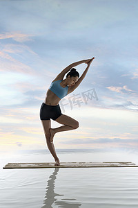 瑜伽广告单摄影照片_年轻女人在水面上练习瑜伽