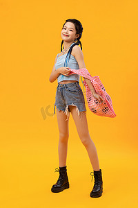 拎购物袋摄影照片_拎着网兜的年轻女孩