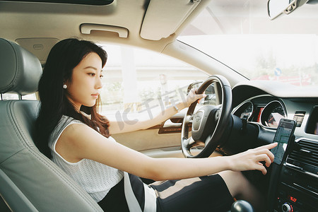 豪华女人摄影照片_开车使用导航的青年女人