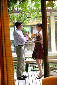 酒店阳台上，男士饮茶，女士饮咖啡