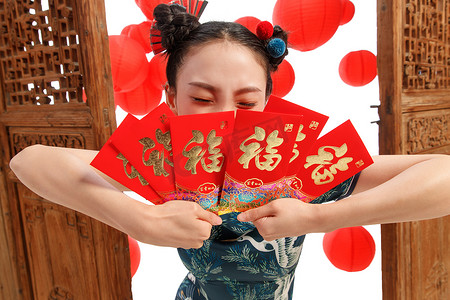 中国如意花纹摄影照片_新年拿着红包的快乐女人