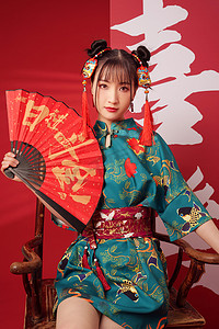 中式文字背景摄影照片_新年拿着扇子的年轻女人
