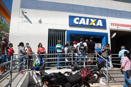 aid摄影照片_(Covid-19: Emergency Aid. April 29,2020, Cotia, Sao Paulo, Brazil: People face a queue at a bank branch of Caixa Economica Federal (CEF) in Granja Vianna in the city of Cotia, Sao Paulo, this Wednesday, 29, due to the possibility of withdraw of them