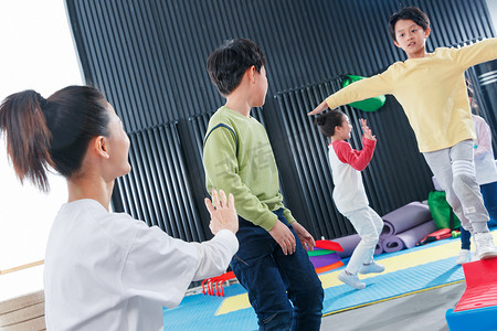 儿童在教练的指导下进行平衡木训练