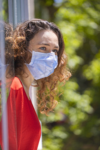 呼吸新鲜空气摄影照片_戴医疗面罩的年轻女子从检疫区呼吸新鲜空气