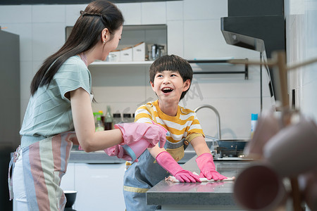 年轻妈妈指导儿子在厨房打扫卫生