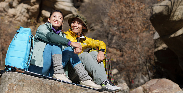 徒步旅行的青年伴侣坐在石头上休息