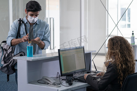 A passenger wearing a face mask and wash his hand with alcohol gel to protect from Coronavirus, COVID-19 pandemic. A Man wearing face mask when traveling by airplane transportation to prevent covid19 virus pandemic. 