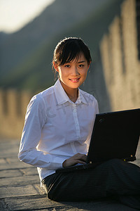 女商务人士在长城上使用笔记本电脑