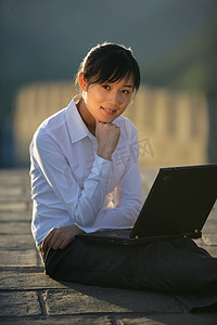 女商务人士在长城上使用笔记本电脑