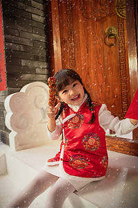 下雪图片摄影照片_吃糖葫芦的快乐小女孩
