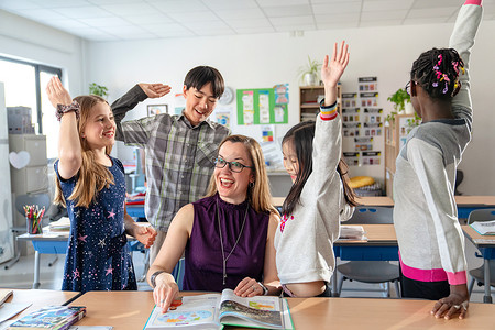 教师辅导小学生在教室里学习