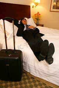 商务人士在酒店床上和衣而卧