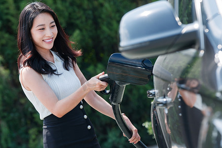 漂亮的青年女人给汽车充电