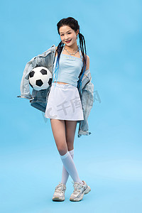 蓝色简洁摄影照片_年轻女孩和足球