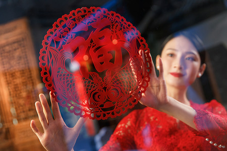 中式福字装饰摄影照片_年轻女人过年贴窗花