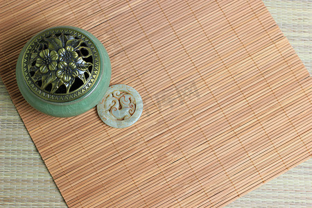 中国的香炉,传统的硫铁矿饰品和竹席背景.安静的生活。复制空间