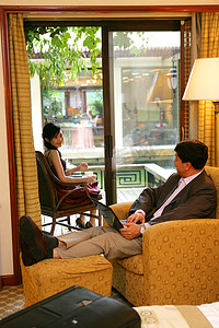 酒店房间里商务人士和年轻女士休闲交谈