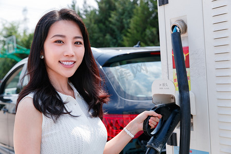 从充电桩取充电枪的青年女人