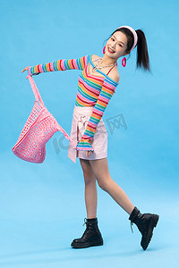 时尚个性的年轻女孩拎着网兜