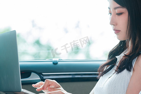 商务女性在汽车内使用笔记本电脑